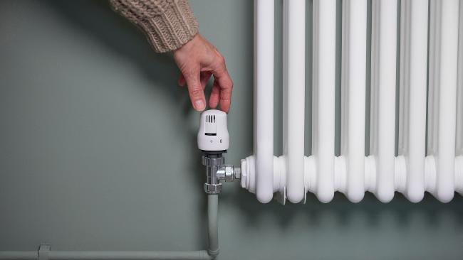 Image of person adjusting radiator temperature Image of person adjusting radiator temperature